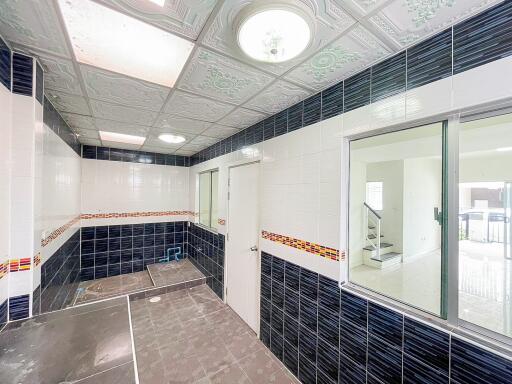 Modern utility room with tile accents and cabinetry