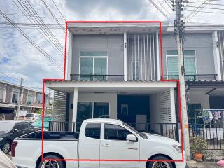 Front view of a residential building with a car parked in the driveway