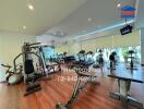 Modern gym area with exercise equipment and wooden flooring