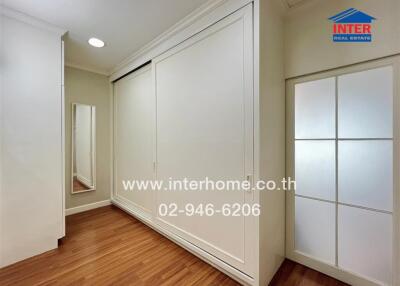 Bedroom with large white closets and wooden flooring