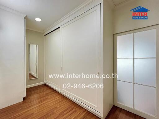 Bedroom with large white closets and wooden flooring