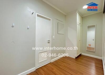 Empty bedroom with wooden floor and white walls