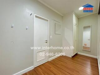 Empty bedroom with wooden floor and white walls