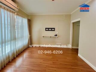 Spacious living room with hardwood floors and large windows