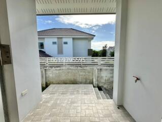 Outdoor view of a building with a partially visible house and tiled walkway