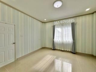 Empty bedroom with patterned wallpaper and a window