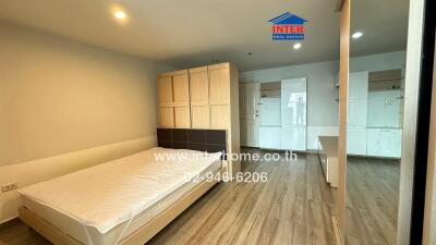 Spacious bedroom with wooden flooring, a bed, and a wardrobe