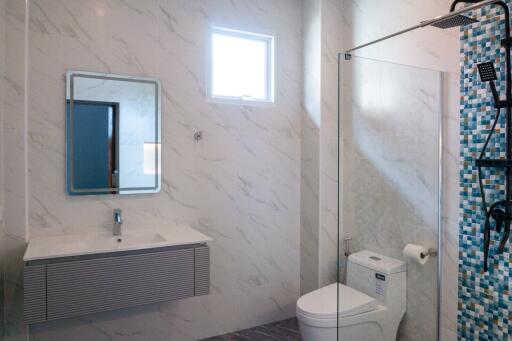 Modern bathroom with a vanity, toilet, and shower area