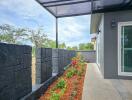 Outdoor area with garden, stone fence, and glass sliding door