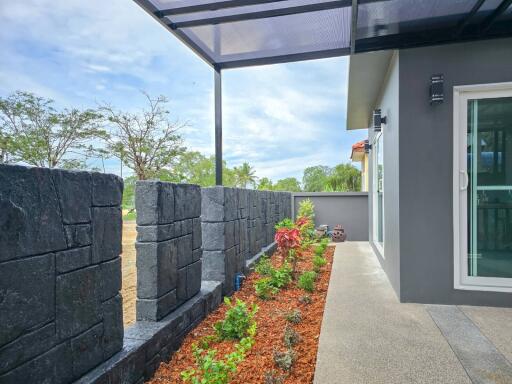 Outdoor area with garden, stone fence, and glass sliding door