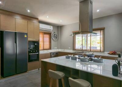 Modern kitchen with island, built-in appliances, and ample lighting