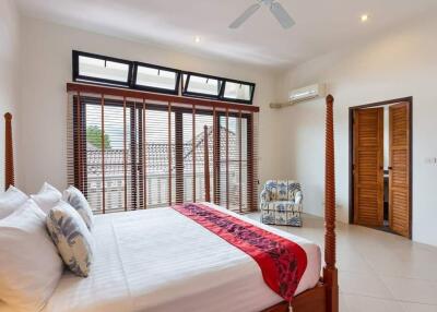 Spacious A/C bedroom with large windows and double bed
