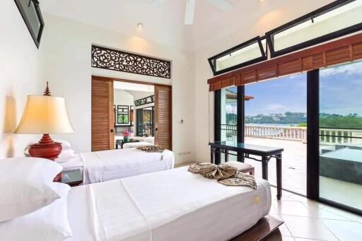 Spacious bedroom with twin beds, large windows, and balcony access