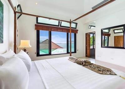 Bright spacious bedroom with a canopy bed and ocean view