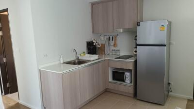 Modern kitchen with wooden cabinets, stainless steel sink, and appliances