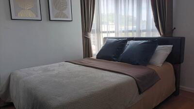 Bedroom with bed, curtains, and wall art