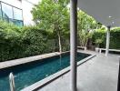 Outdoor pool area with greenery