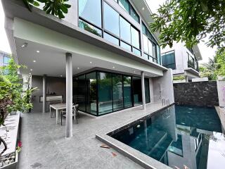 Modern residential patio with glass walls and pool