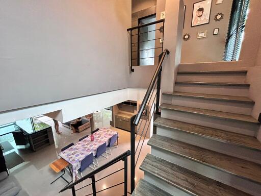 Modern open-concept living space including staircase, dining area with table, and view of the living room