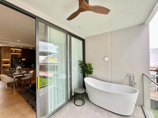 Modern balcony with a freestanding bathtub and a ceiling fan