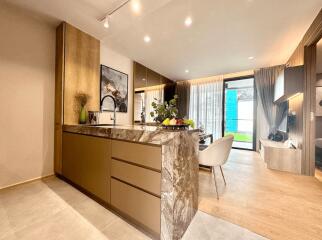 Modern kitchen interior with a marbled island and open living space