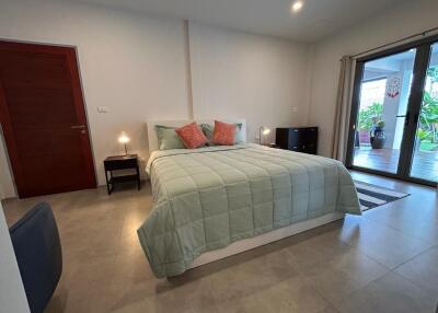 spacious bedroom with large bed and balcony access