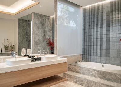 Modern bathroom with double sink, bathtub, and large mirror