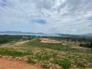 Panoramic view of undeveloped land with distant water body and mountains