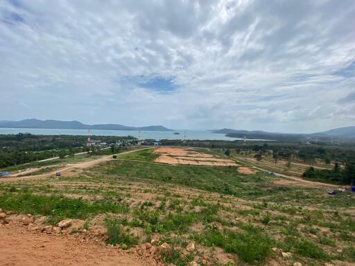 Panoramic view of undeveloped land with distant water body and mountains