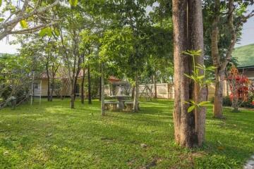 Spacious garden with lush greenery and seating area