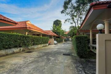 Driveway leading to houses with red-tiled roofs