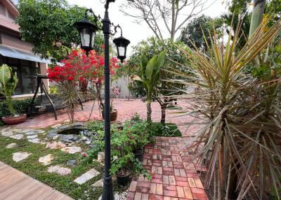 Beautifully maintained backyard garden with paved pathways and plants