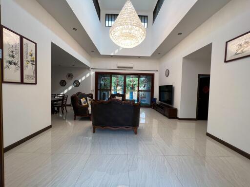 Spacious and well-lit living room with large chandelier