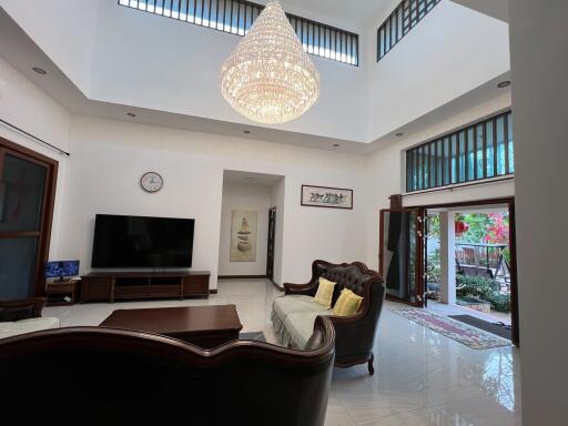 Spacious living room with high ceiling and chandelier