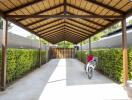 Covered carport with hedge-lined driveway