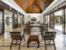 Spacious and well-lit living area with wooden ceiling and open glass doors