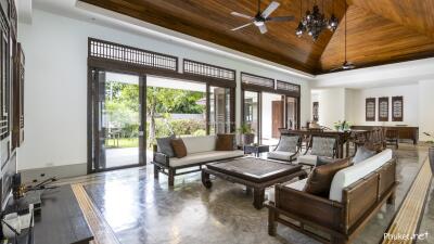 Spacious living room with wooden ceiling, large windows, and modern furniture