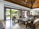 Spacious living room with wooden ceiling, large windows, and modern furniture