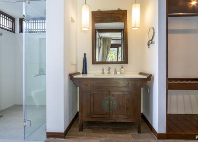 Modern bathroom with a wooden vanity, shower area, and dressing area