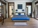 Spacious bedroom with blue bedding and modern decor