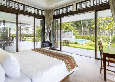 Spacious bedroom with large windows and pool view