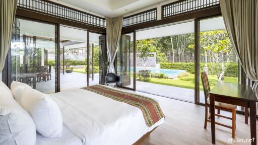 Spacious bedroom with large windows and pool view