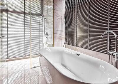 Modern bathroom with a large bathtub and floor-to-ceiling windows with blinds