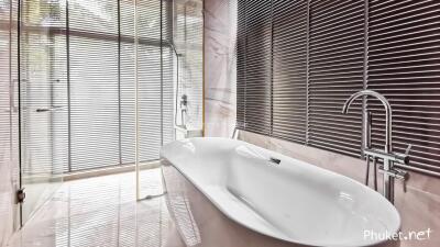 Modern bathroom with a large bathtub and floor-to-ceiling windows with blinds