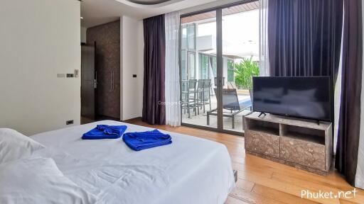 Bedroom with a bed, TV, and view of the outdoor area through a sliding glass door