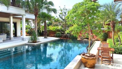 Outdoor pool area with adjacent seating and greenery