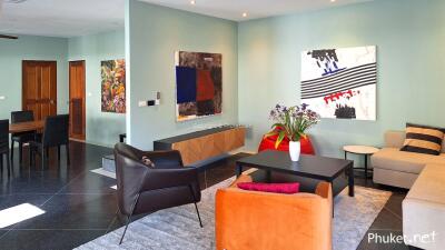 Modern living room with colorful decor and adjacent dining area