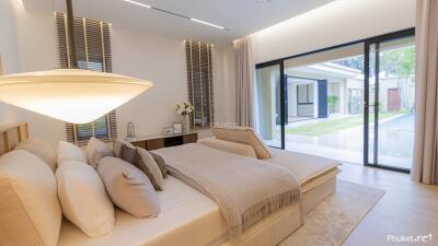 Modern bedroom with large sliding glass doors leading to an outdoor area