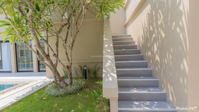 Outdoor area with greenery, stairs, and pool view