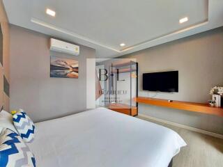 Modern bedroom with wall-mounted TV and air conditioning